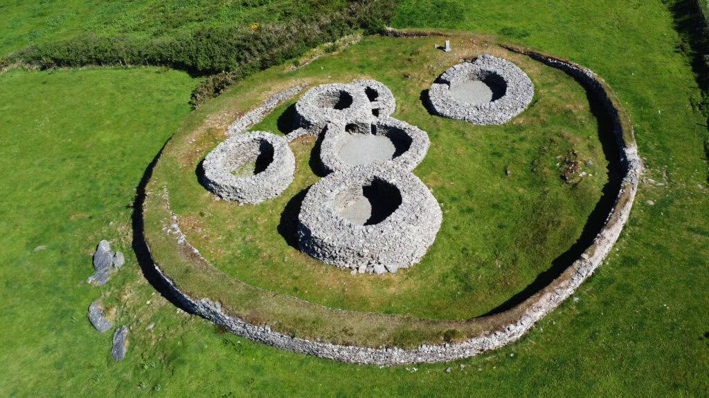 Caherdorgan Stone Fort with circular stone walls on a grassy cliffside.