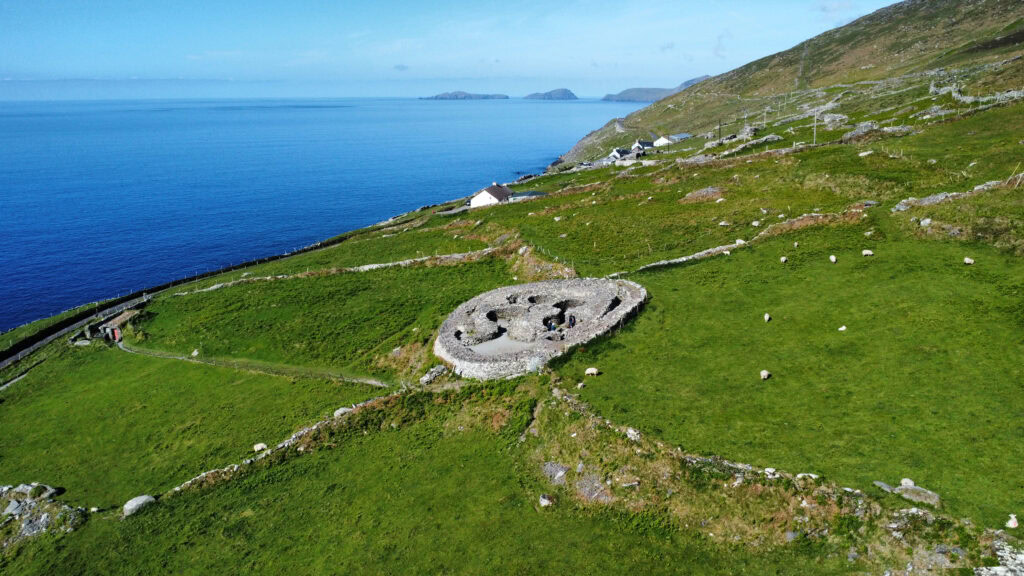 Aerial image of Cashel Murphy, showing concentric stone walls and internal structures on a green slope.