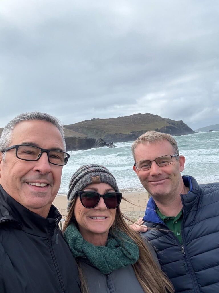 Steven with two tour guests smiling for a selfie at a coastal viewpoint on the Dingle Peninsula, County Kerry.