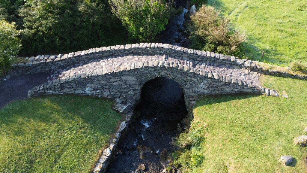 Garfinny Bridge's slightly pointed stone arch supported by distinctive corbelled stonework above the Garfinny River.