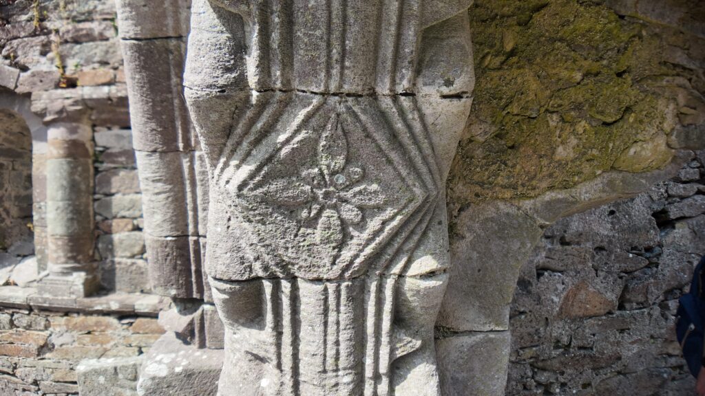 Close-up of a carved Romanesque doorway capital at Kilmalkedar Church, displaying medieval stone craftsmanship in County Kerry.