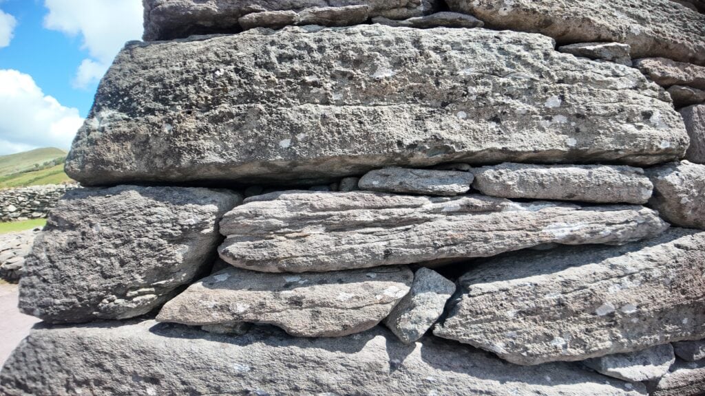Close-up of the corbelled sandstone masonry at Gallarus Oratory, showing tightly fitted dry-stone construction on the Dingle Peninsula.