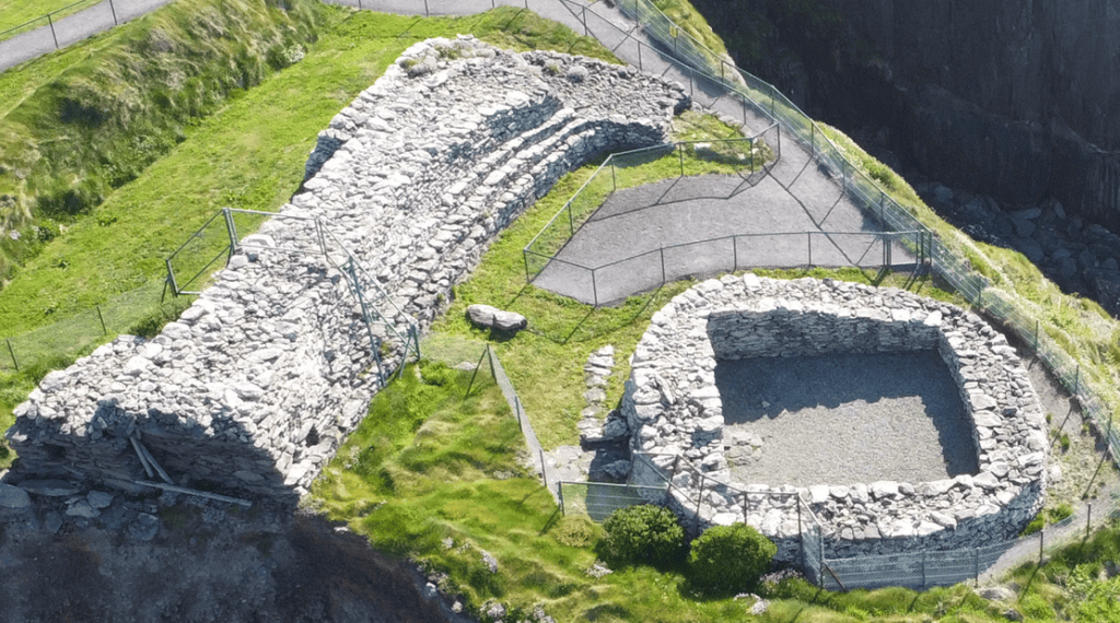 Reconstructed clochán beside the surviving drystone walls of Dún Beag Stone Fort on the Dingle Peninsula, County Kerry.