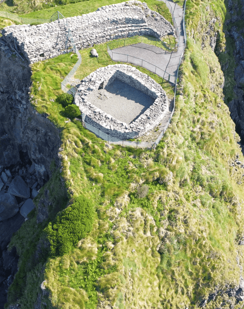 Aerial view of the reconstructed clochán and surviving drystone rampart at Dún Beag Stone Fort on the Dingle Peninsula, County Kerry.