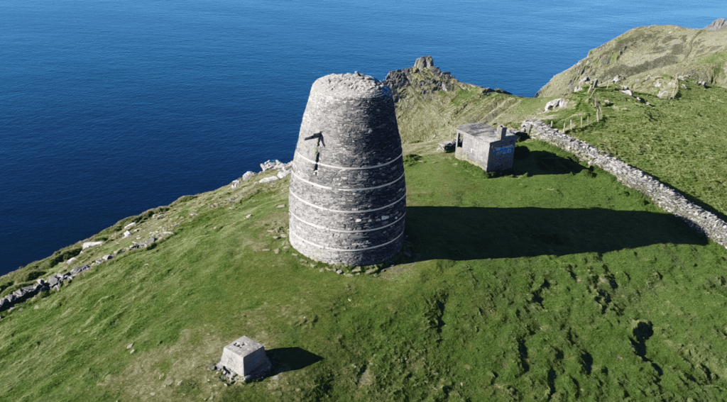 Aerial view of Eask Tower beside the remains of a Second World War lookout post above the Atlantic coast on the Dingle Peninsula.