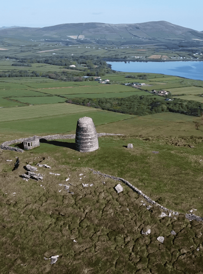 Aerial view of Eask Tower and the remains of a Second World War lookout overlooking Dingle Harbour and the surrounding countryside.