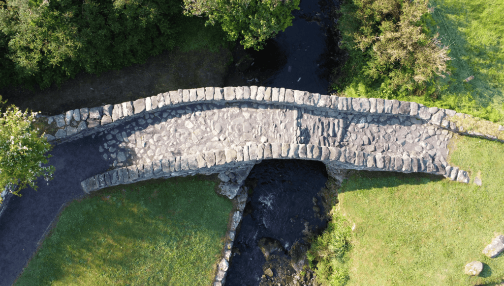 Traditional dry-laid stone paving and low parapet walls on Garfinny Bridge in County Kerry.