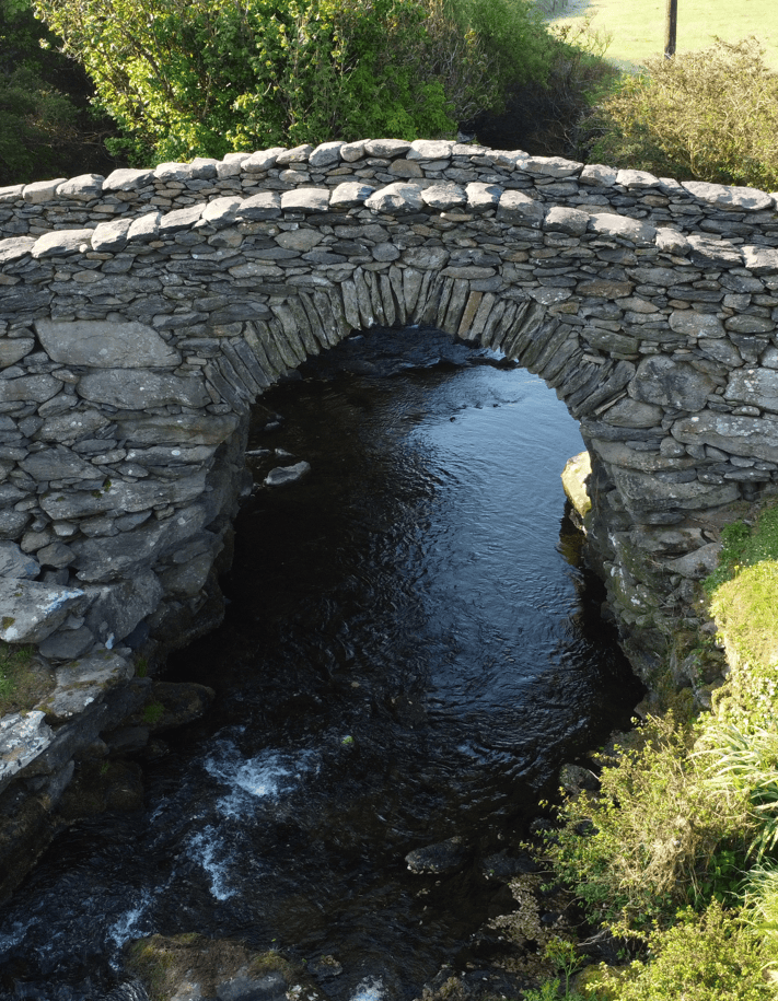 Side view of Garfinny Bridge showing its single-span stone arch crossing the Garfinny River in County Kerry.