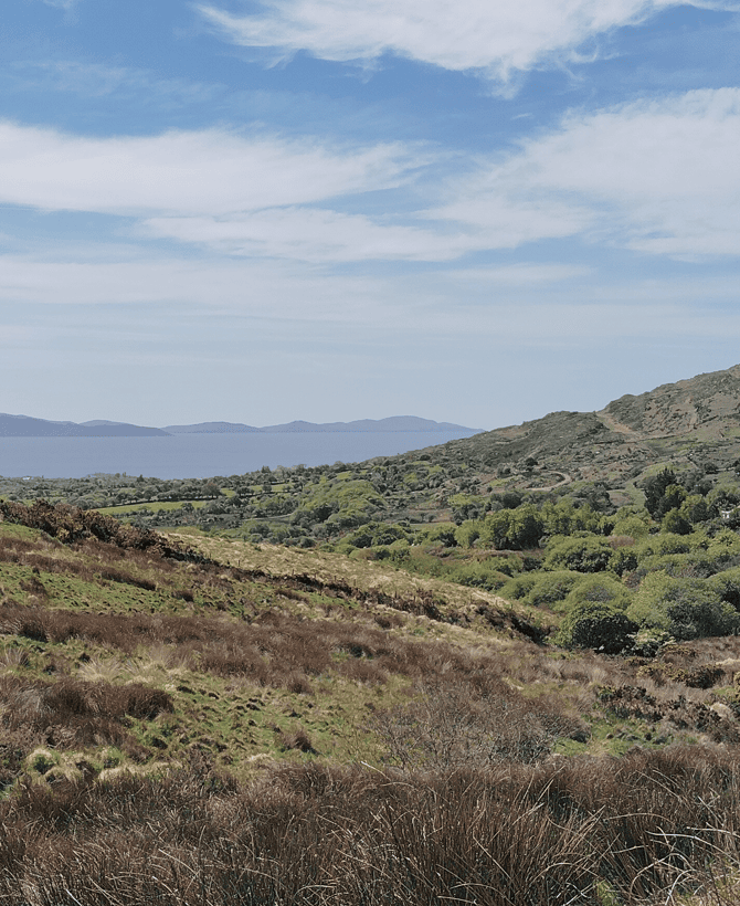 Rugged hillside landscape near Staigue Fort overlooking green countryside towards the distant Atlantic coastline.