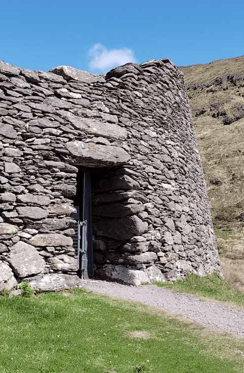 Narrow lintelled entrance through the massive dry-stone wall of Staigue Fort, with the Kerry hillside rising behind.