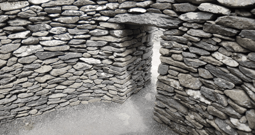 Interior passage of a Fahan Clochán showing thick dry-stone walls and the corbelled construction technique.