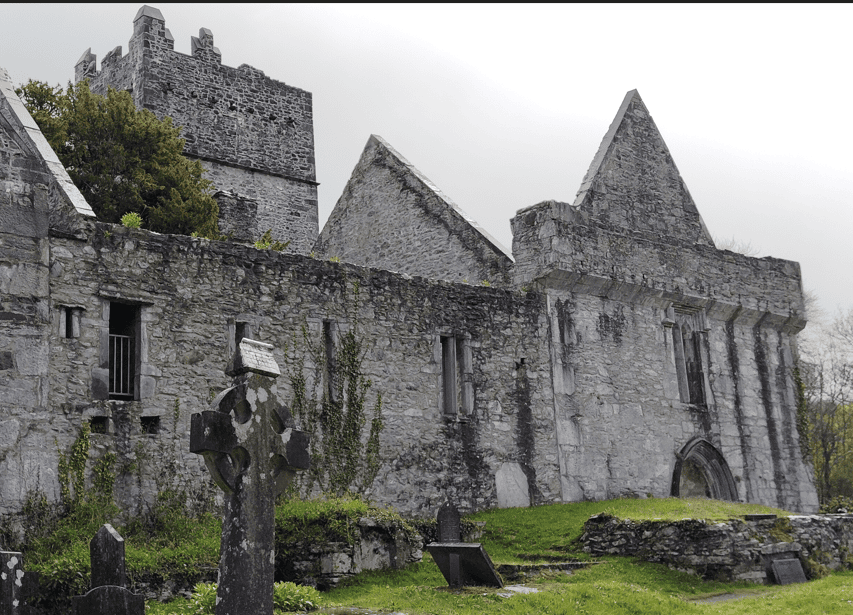 Stone domestic range and adjoining gabled buildings within the ruins of Muckross Abbey in Killarney National Park.