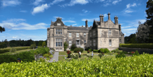 Muckross House and its formal gardens beneath a blue sky within Killarney National Park, County Kerry.