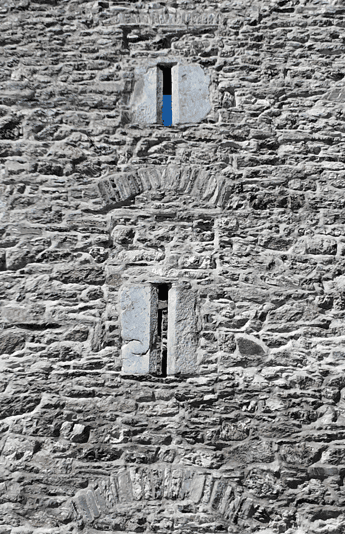 Stone wall of Ross Castle showing two narrow openings and a relieving arch within the historic masonry.