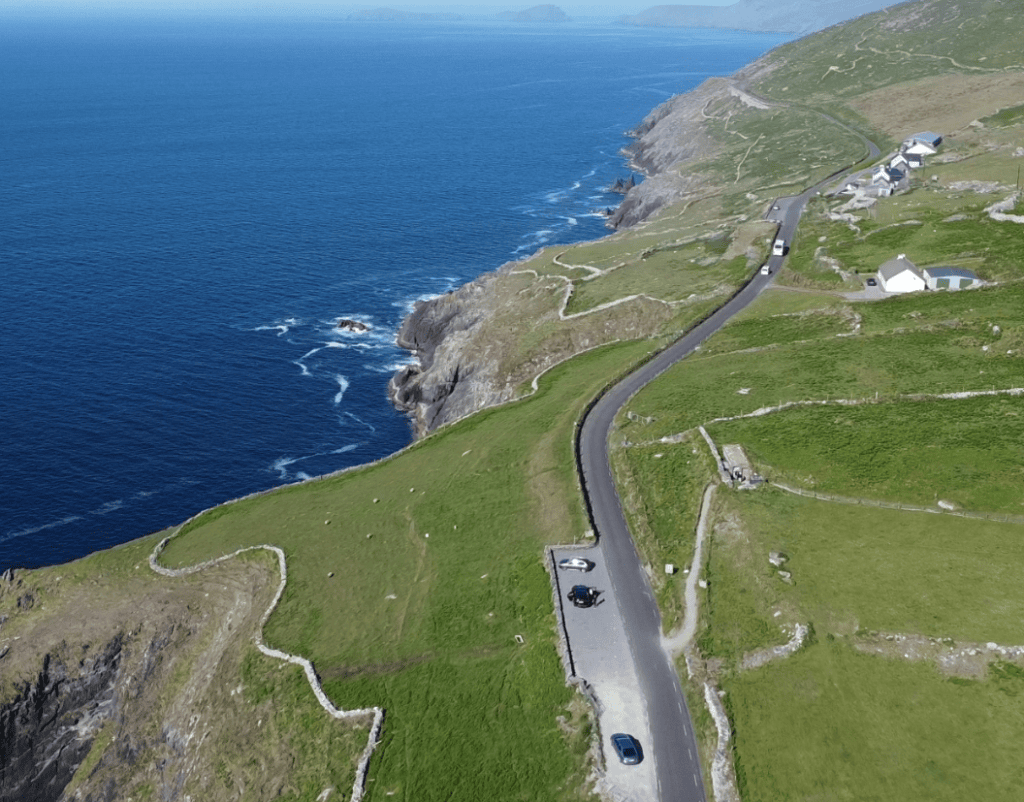 Slea Head Drive following the steep Atlantic coastline through green fields on the western Dingle Peninsula.