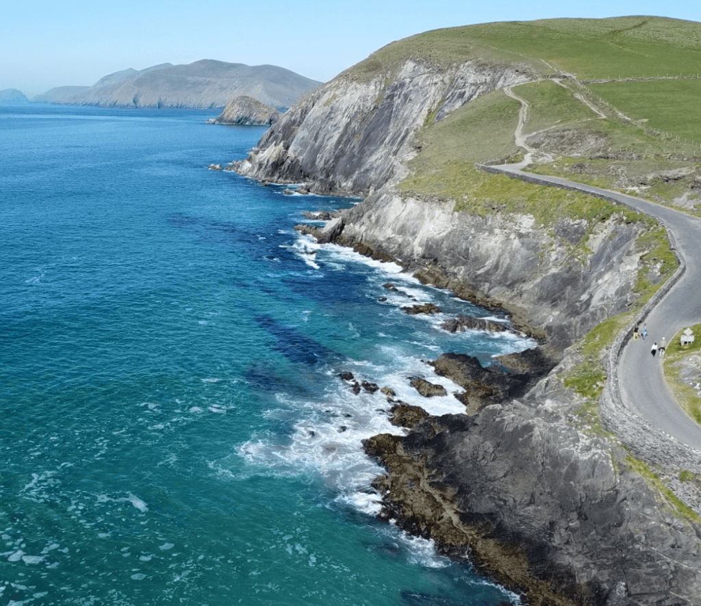 Slea Head Drive winding above steep Atlantic cliffs and turquoise coastal waters on the western Dingle Peninsula.