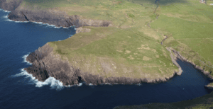 Aerial view of Brandon Creek on the Dingle Peninsula, showing the narrow inlet, rocky headlands and surrounding green fields.